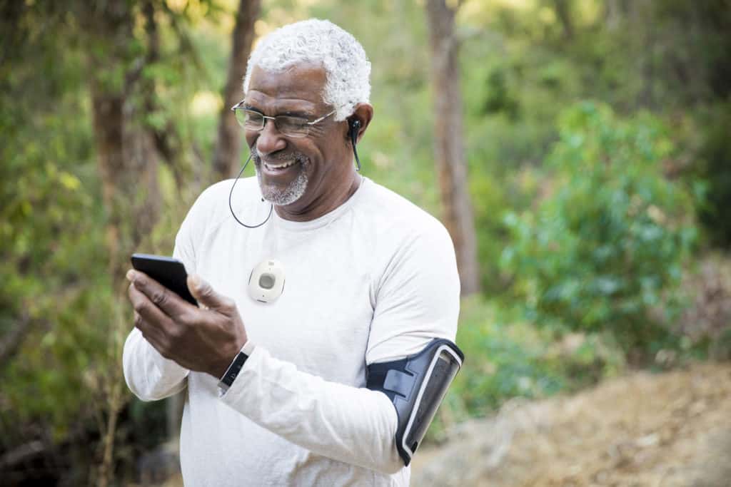 Mature man in sportswear with medical alert device